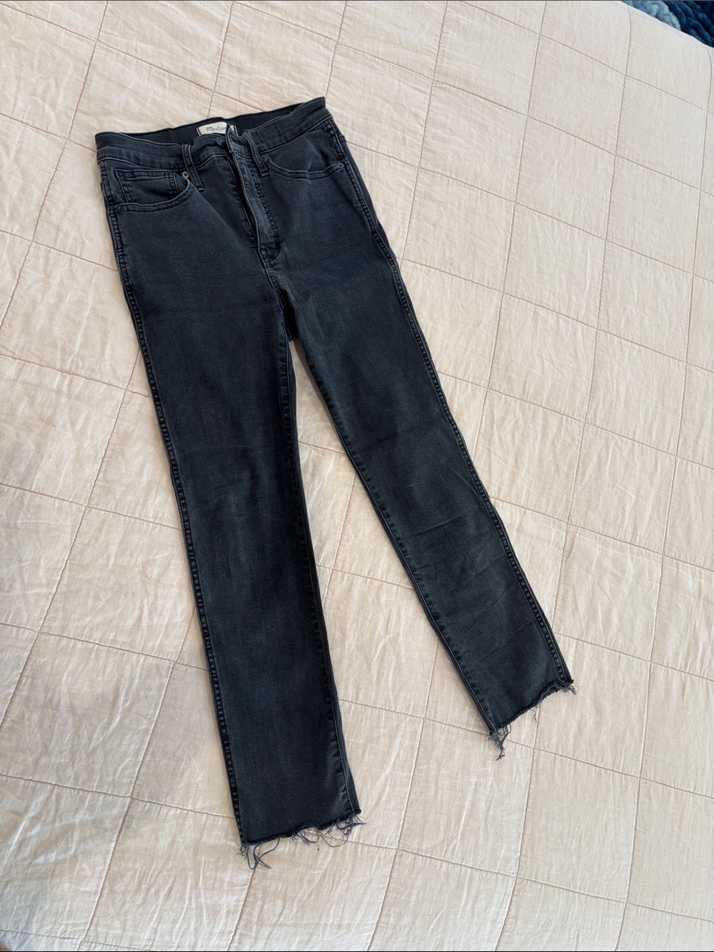 Madewell faded black jeans with frayed bottoms.